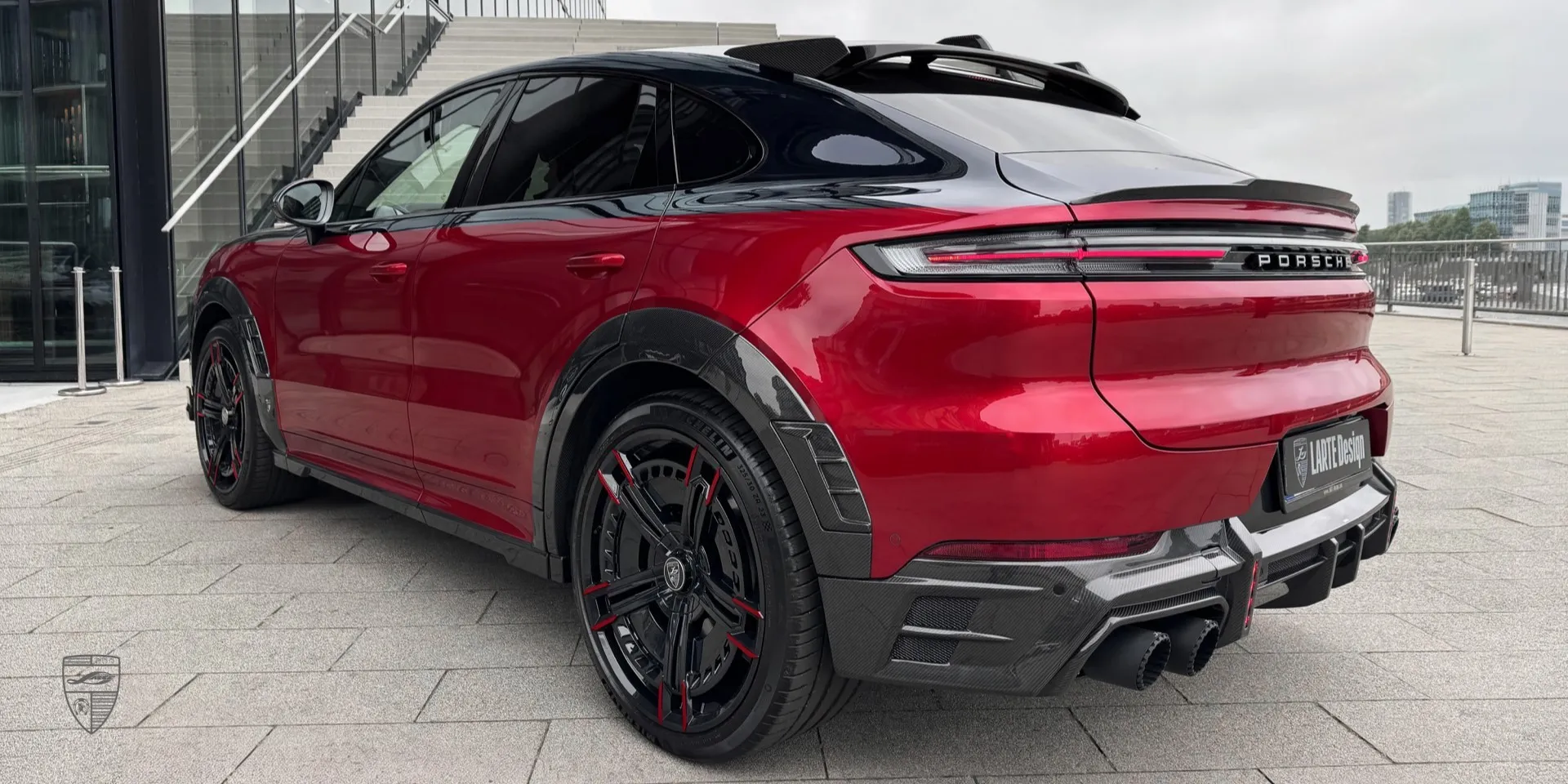Rear angle of the red Porsche Cayenne Coupe showcasing the body kit and diffuser