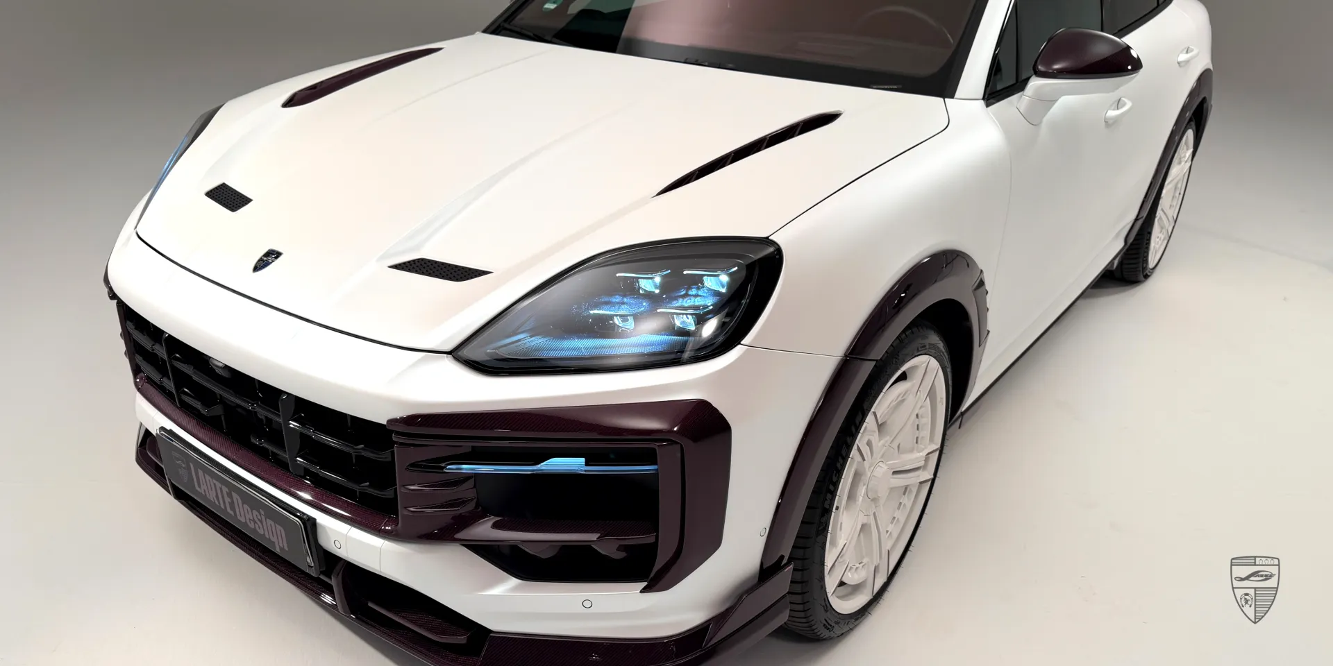 Optik mit tiefergelegter Federung: weißer Porsche Cayenne mitpinkem Trocken‑Kohlefaser