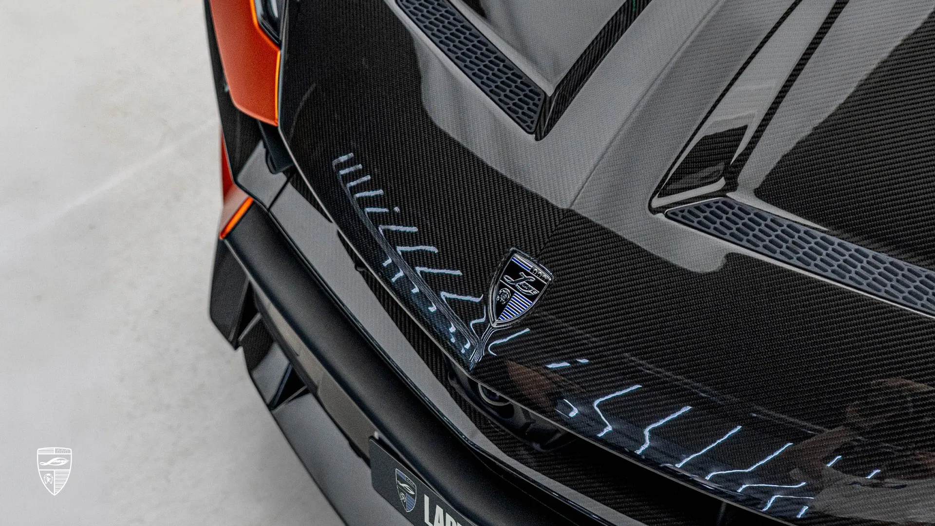 Lamborghini URUS SE modified with carbon fiber shown in a close-up of the branded hood detail