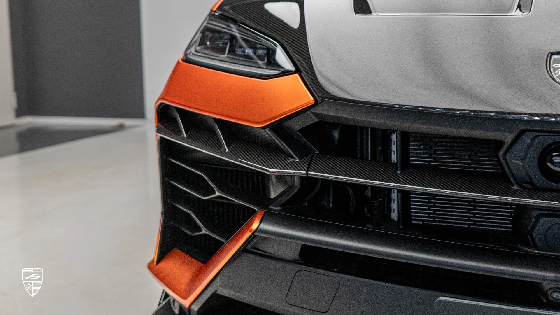Lamborghini URUS SE with carbon fiber featuring a close-up front light and grille detail