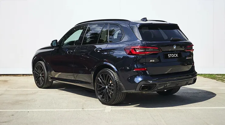 Rear angle view on a BMW X5 G05 with a body kit giving the car a custom appearance