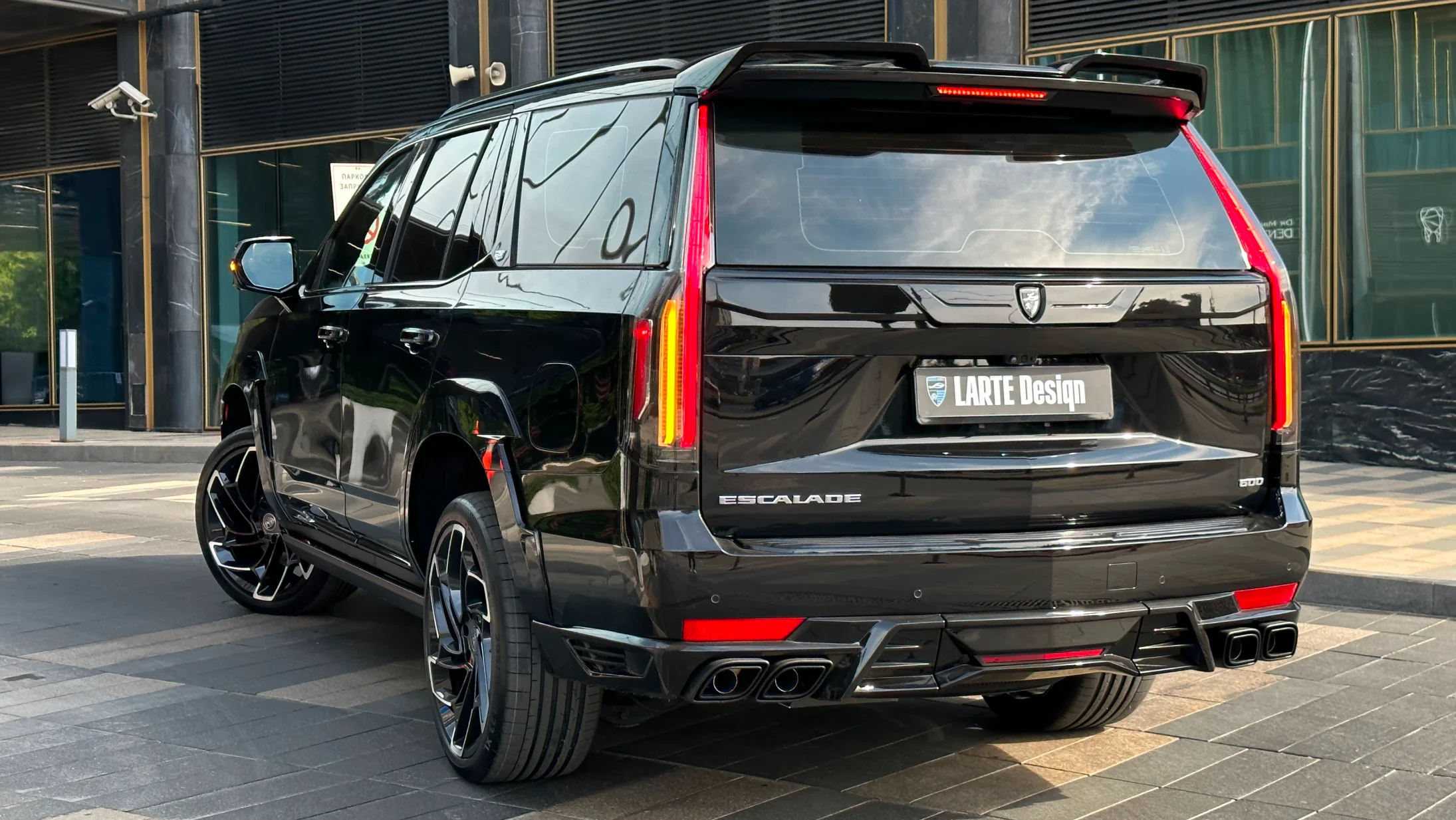 Rear angle view on a Cadillac Escalade with a body kit giving the car a custom appearance