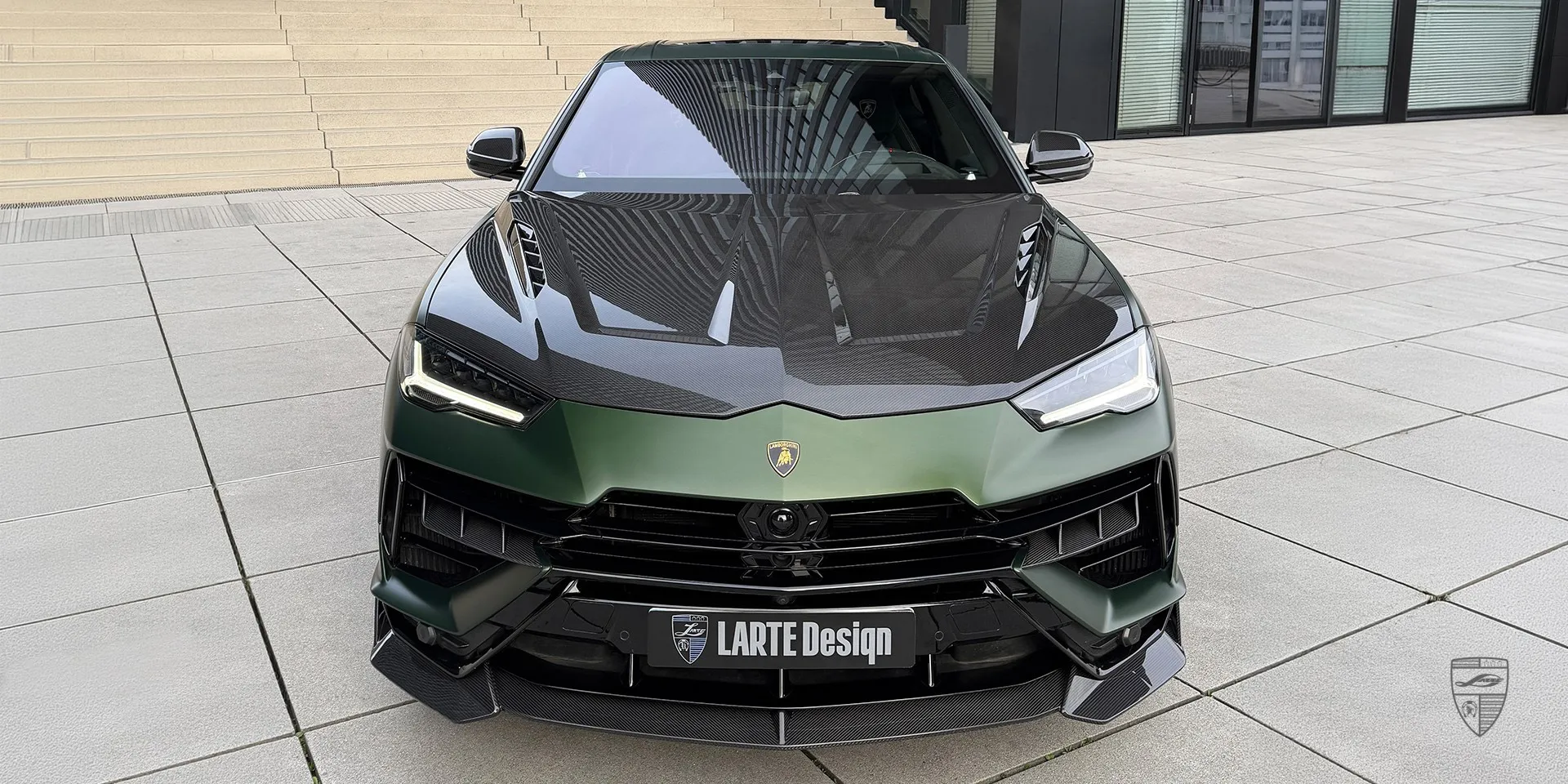 Frontansicht des mattgrünen Lamborghini Urus S als Leistungs‑SUV mit Carbon-Grill‑Styling